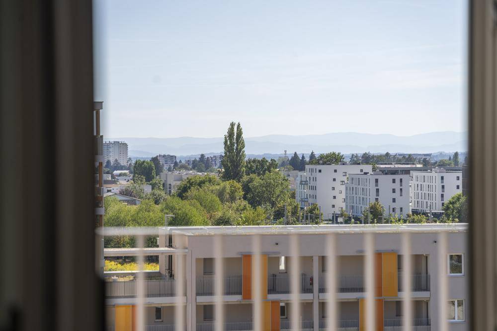 Weitblick auf moderne Wohngebäude und die umliegende Berglandschaft.