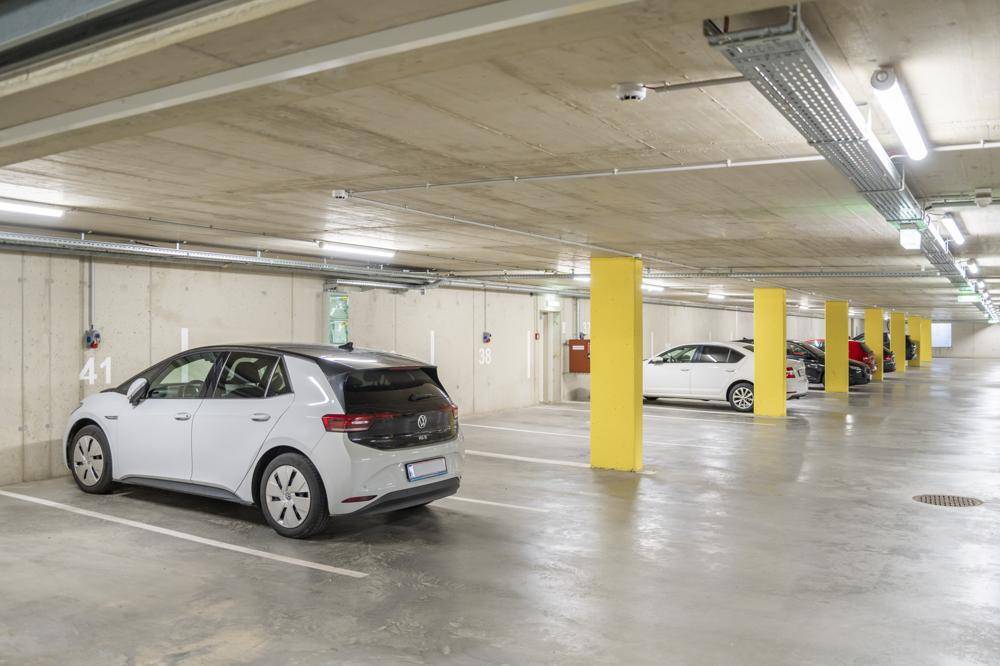 Tiefgarage mit mehreren Stellplätzen und heller Beleuchtung.