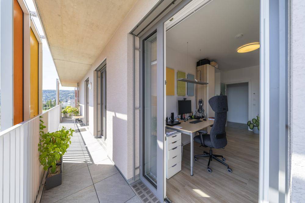 Balkon mit Blick in das helle Arbeitszimmer, das eine angenehme Atmosphäre bietet.