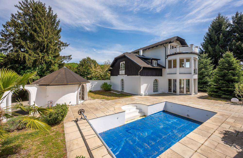 Große Steinterrasse mit eingelassenem Pool und Blick auf die elegante Villa.