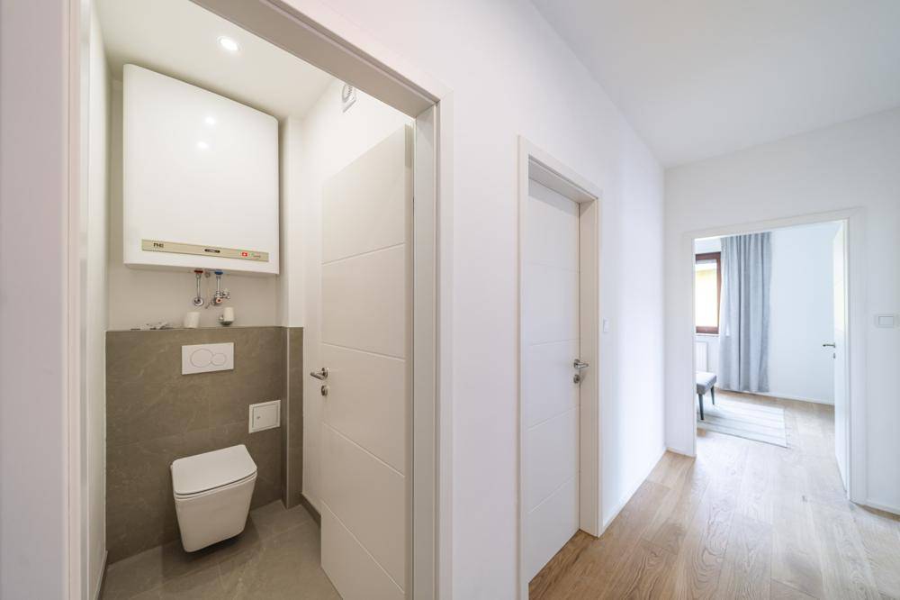 Modernes Gäste-WC mit wandhängender Toilette und Heizungsanlage.