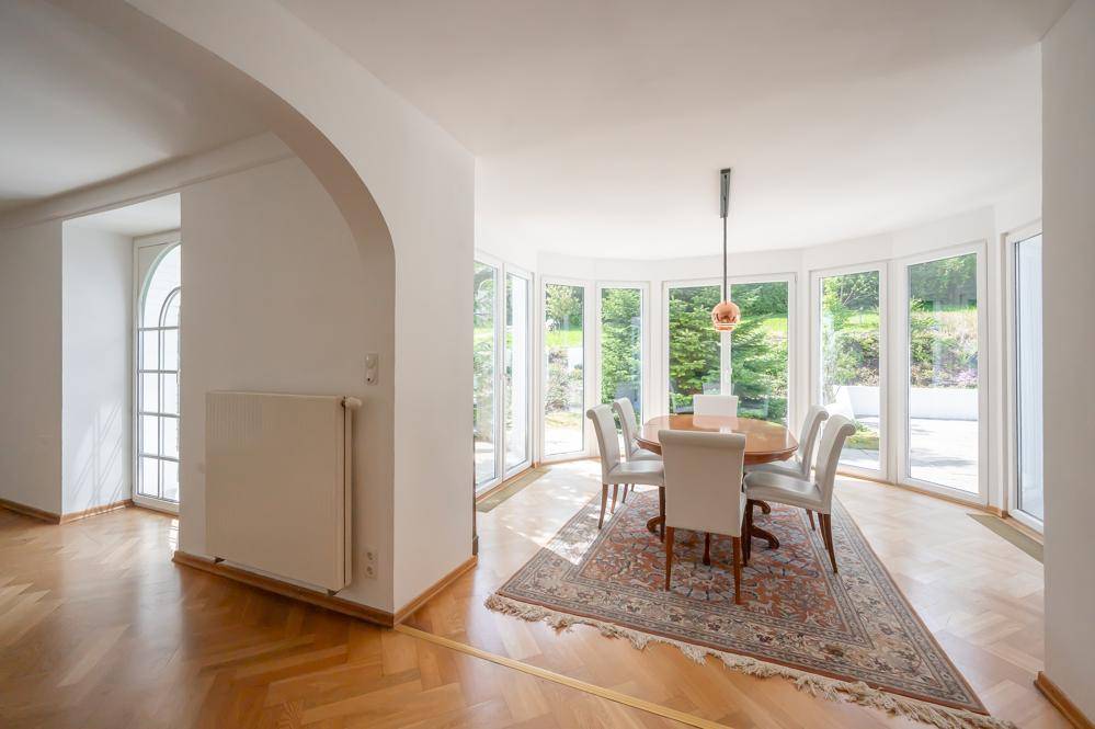 Heller Essbereich mit Rundumblick durch große Fenster und Parkettboden.