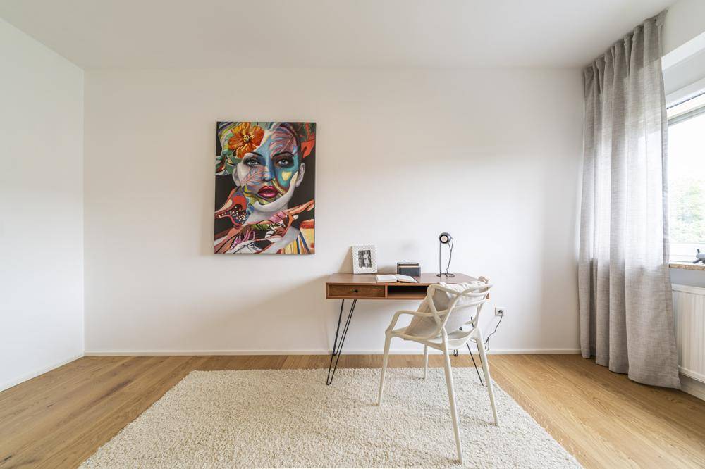 Detailansicht des Arbeitszimmers mit Schreibtisch und auffälligem Kunstwerk an der Wand.
