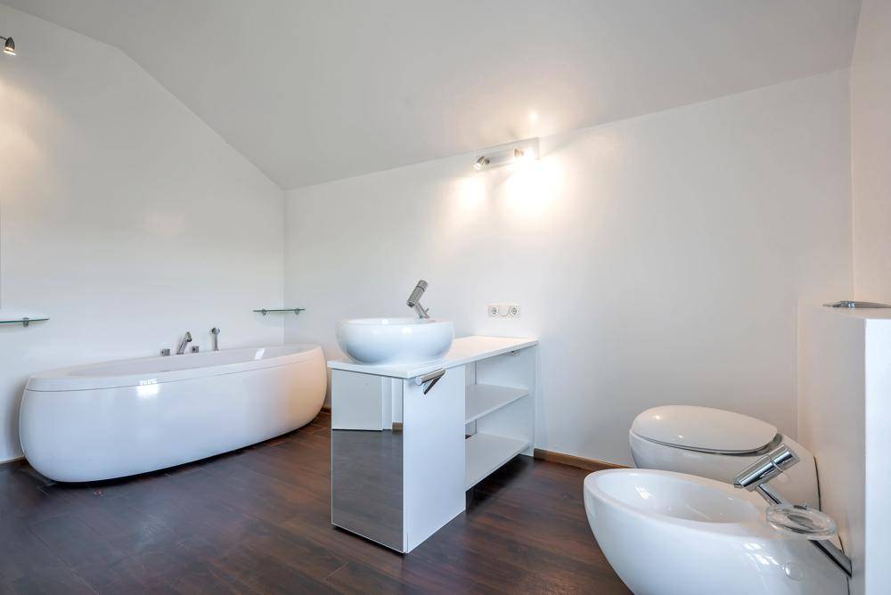 Modernes Badezimmer mit freistehender Badewanne, Bidet und Waschtisch.