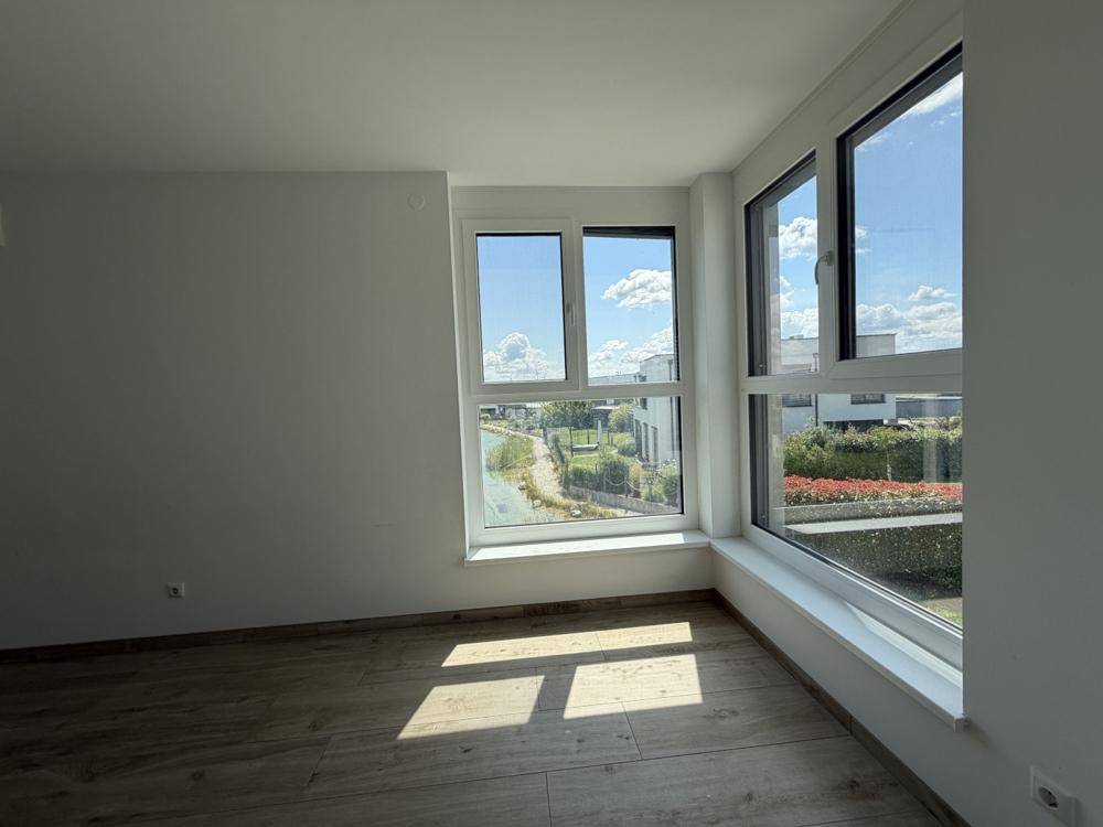 Helles Schlafzimmer mit großen Fenstern, die einen weiten Blick auf die Umgebung bieten.