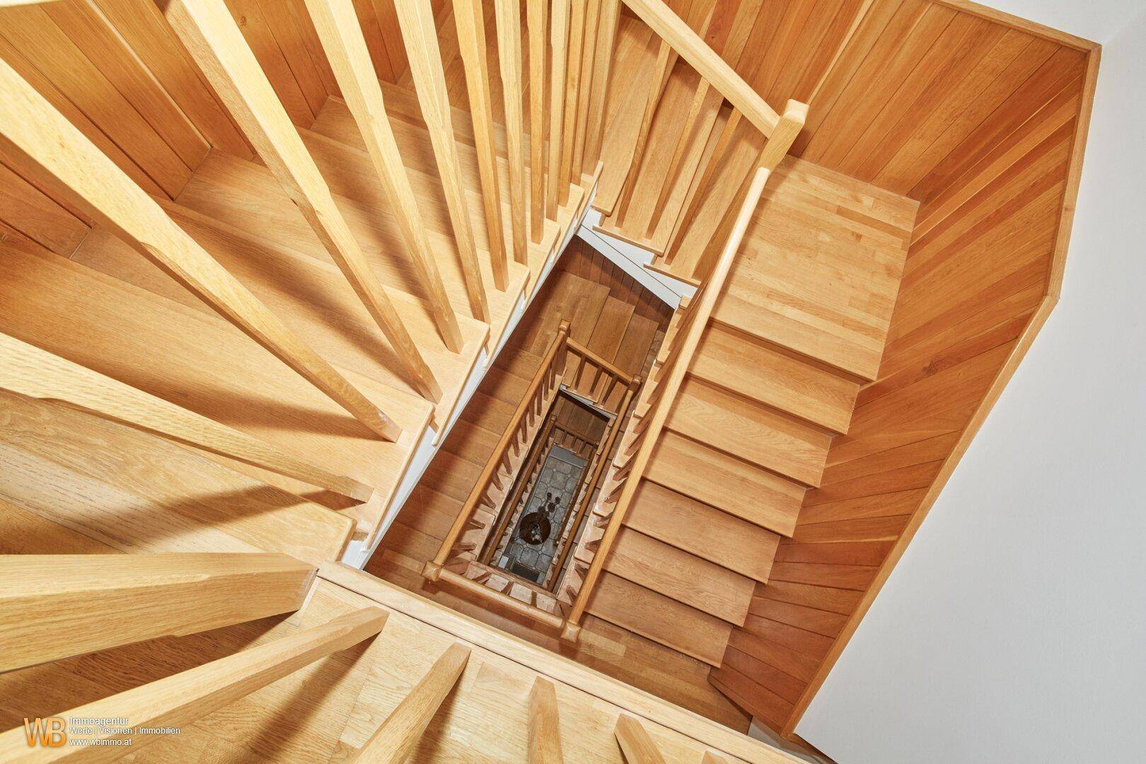 Elegante Holztreppe mit offener Bauweise, die die verschiedenen Ebenen des Hauses verbindet.