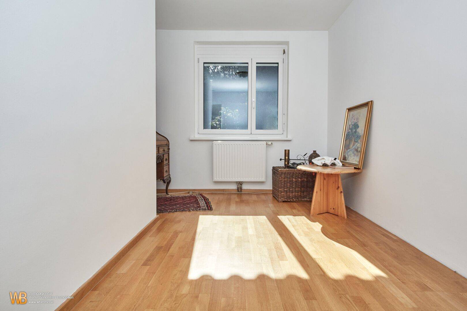 Heller, leerer Raum mit Holzboden und Fenster, ideal für individuelle Gestaltungsmöglichkeiten.