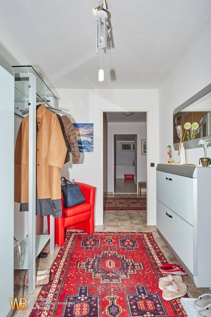 Einladende Diele mit Teppich, Garderobe und Zugang zu weiteren Wohnbereichen.