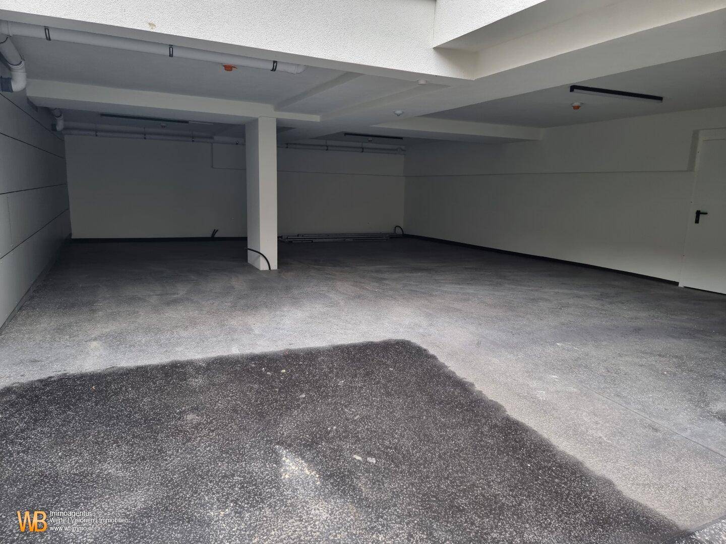 Geräumiger Kellerraum mit rohem Betonboden und sichtbaren Deckenstrukturen, ideal als Lagerfläche.