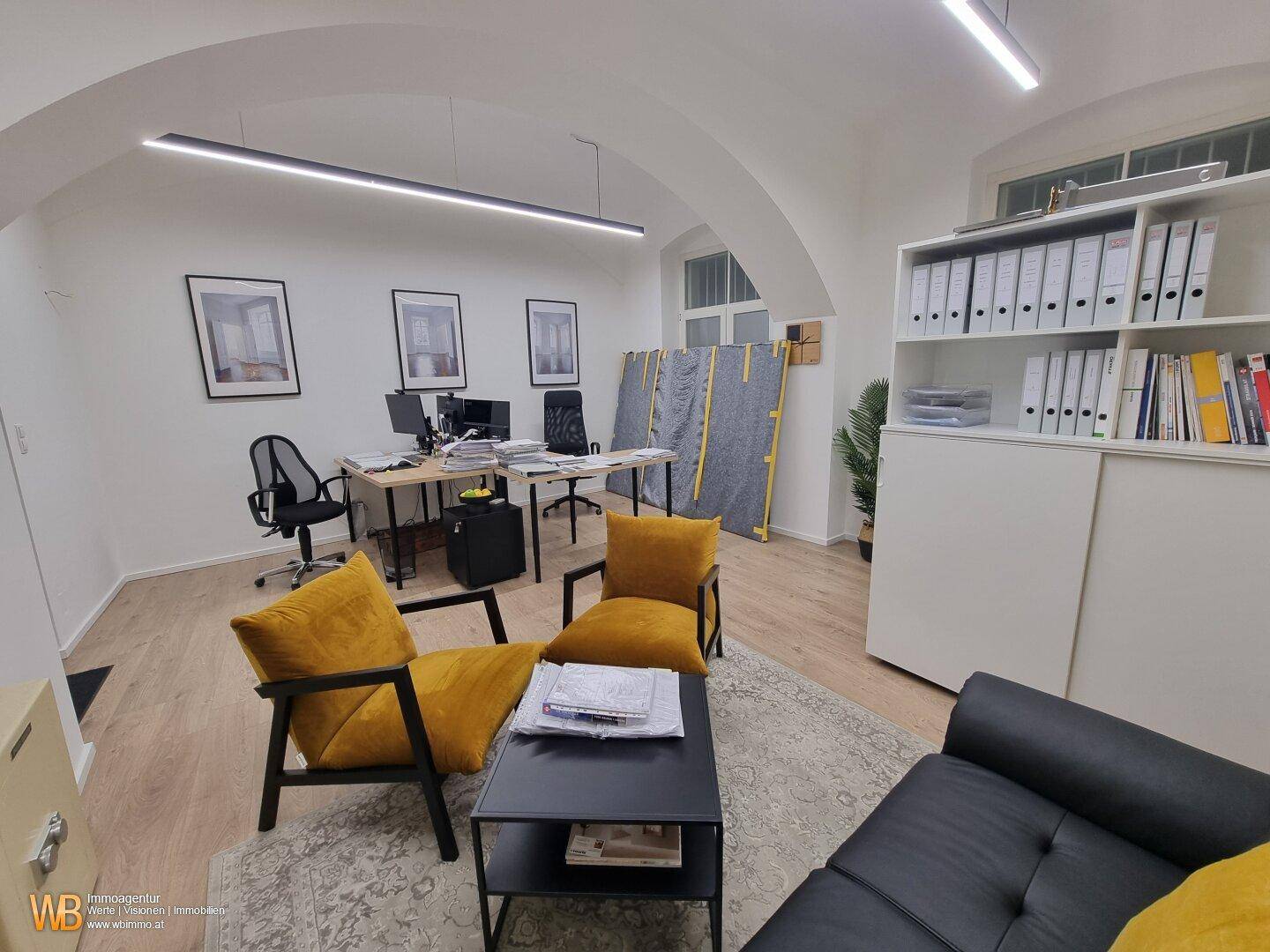 Büro mit Sitzecke, Holzboden und modernen Möbeln, ideal für Besprechungen oder Pausen.