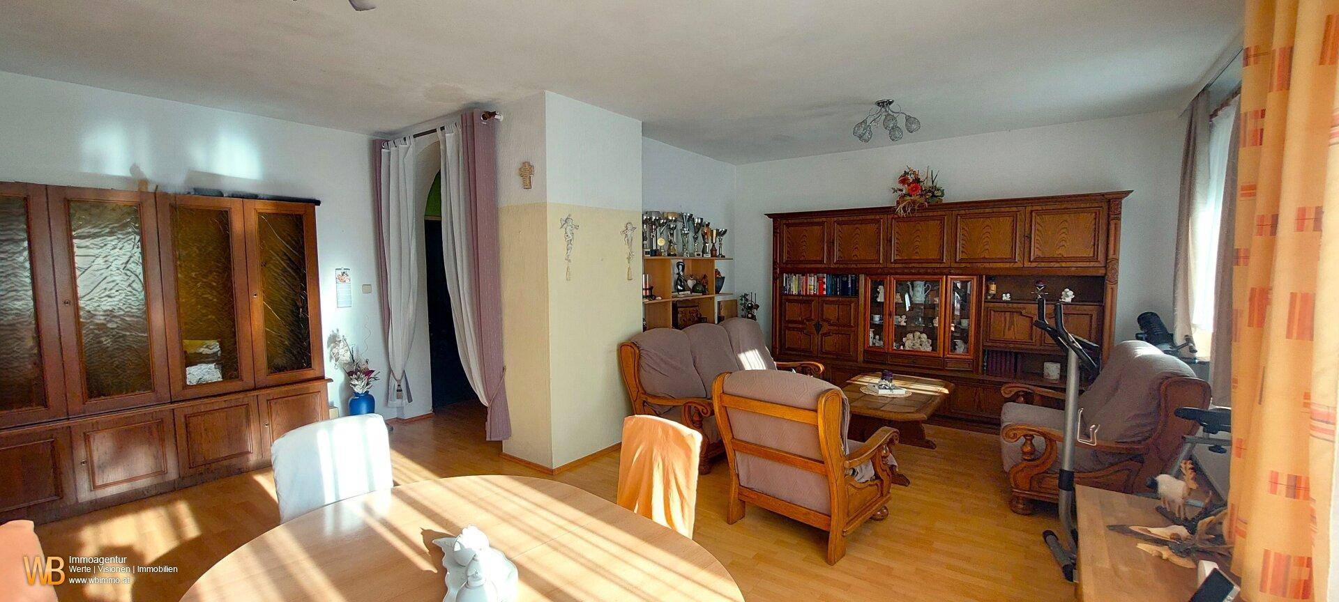 Geräumiger Wohn- und Essbereich mit traditionellen Holzmöbeln und Parkettboden.