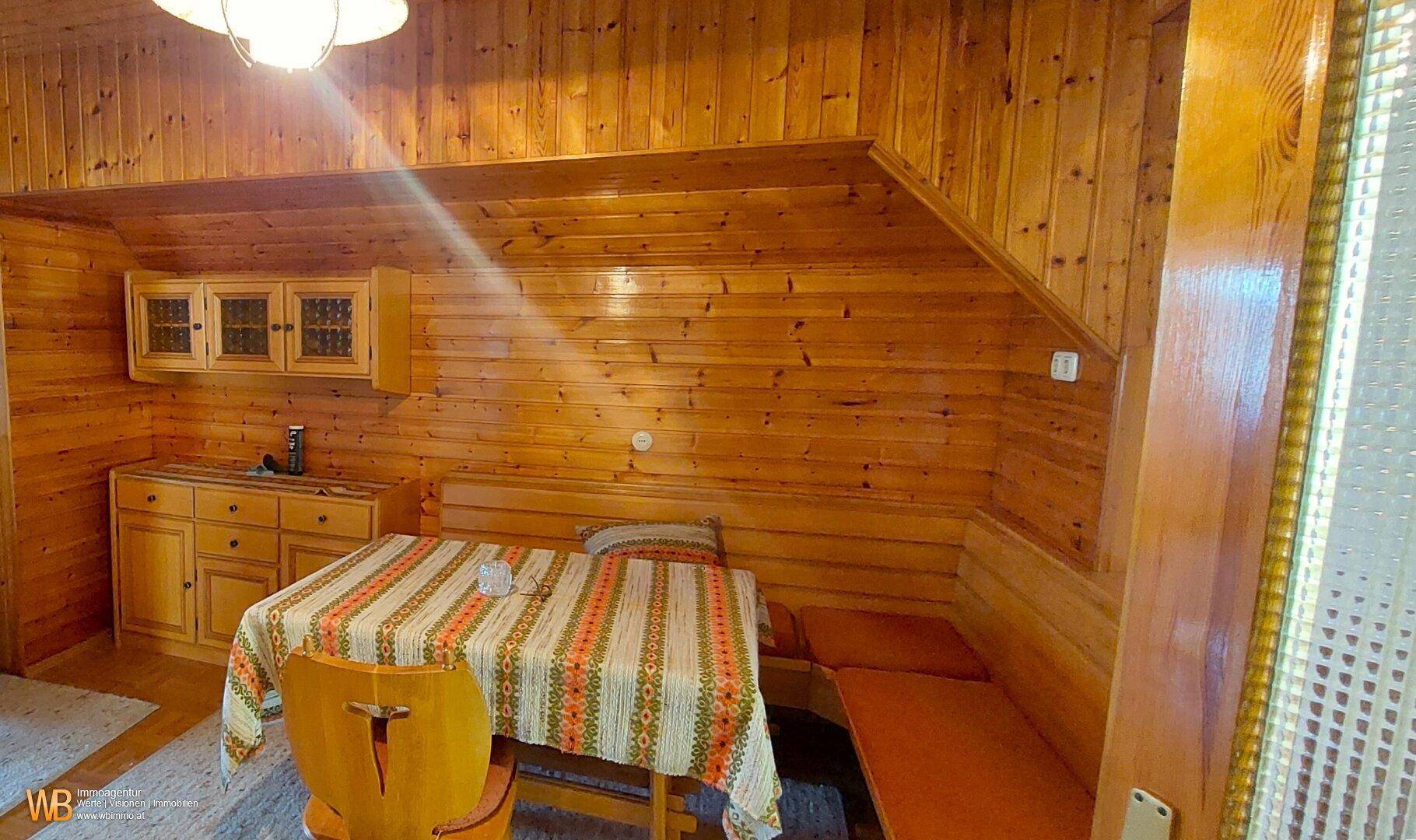 Kleine Küchenzeile im Dachgeschoss mit Holzwänden, einer Essecke und rustikalem Charme.