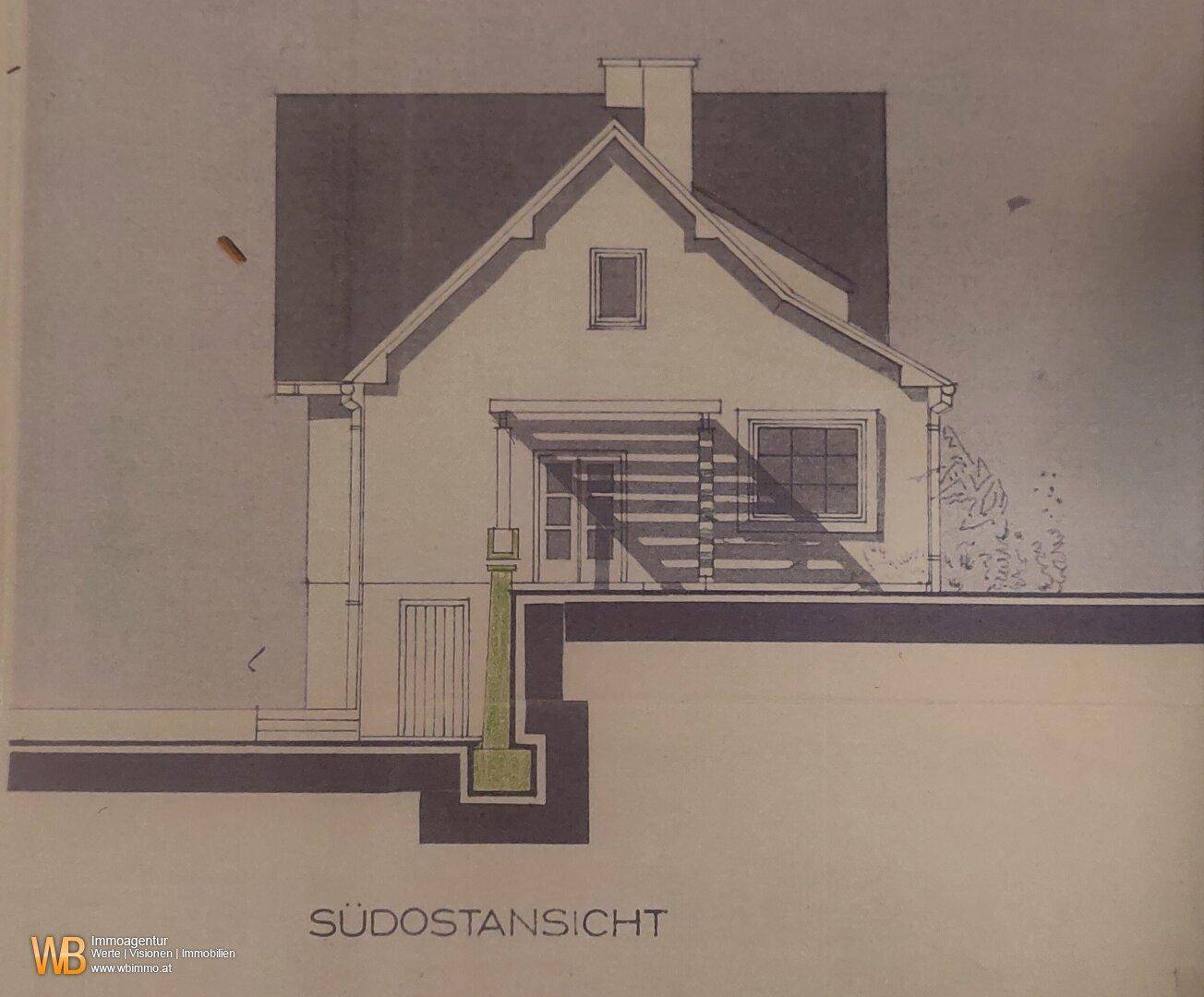 Seitenansicht des Hauses mit Giebeldach und einer überdachten Terrasse oder Pergola.
