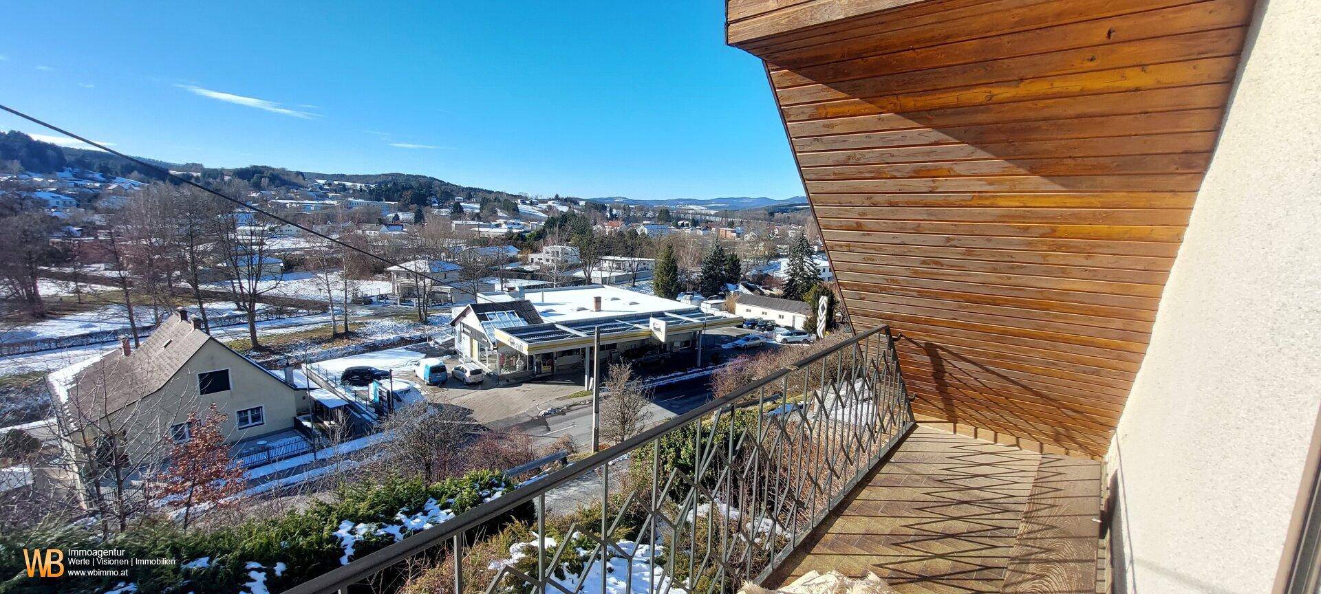 Weitläufiger Blick vom Balkon über die verschneite Umgebung und die darunterliegende Straße.