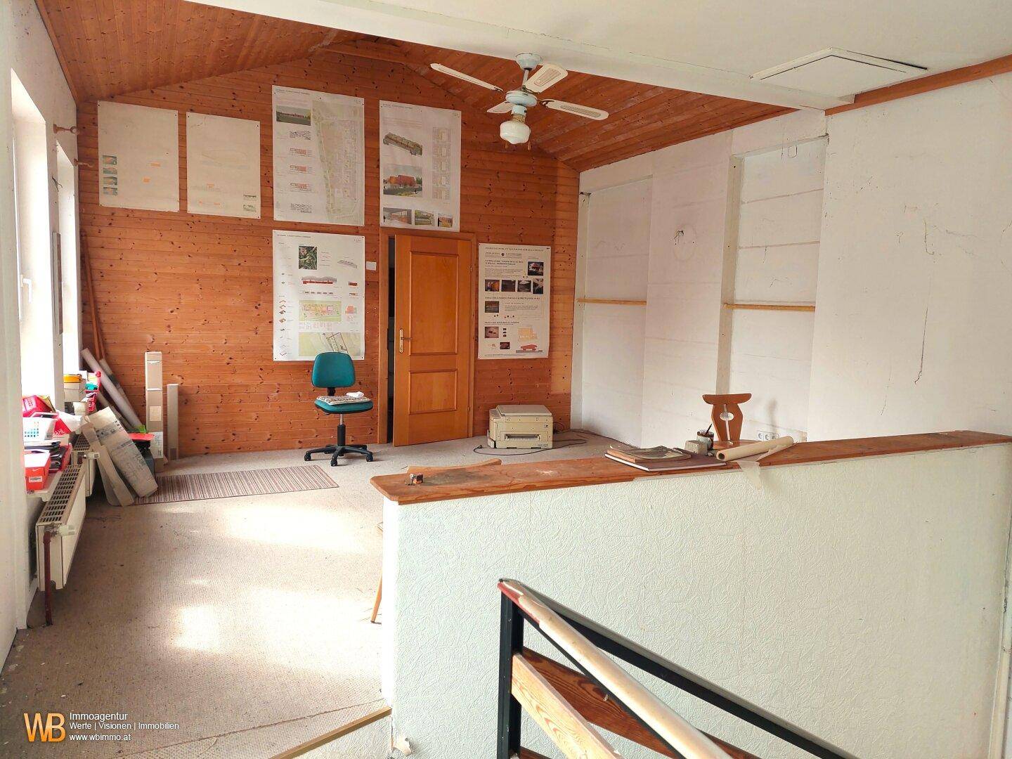 Geräumiges Arbeitszimmer mit Holzvertäfelung, Dachschräge und Deckenventilator, vielseitig nutzbar.