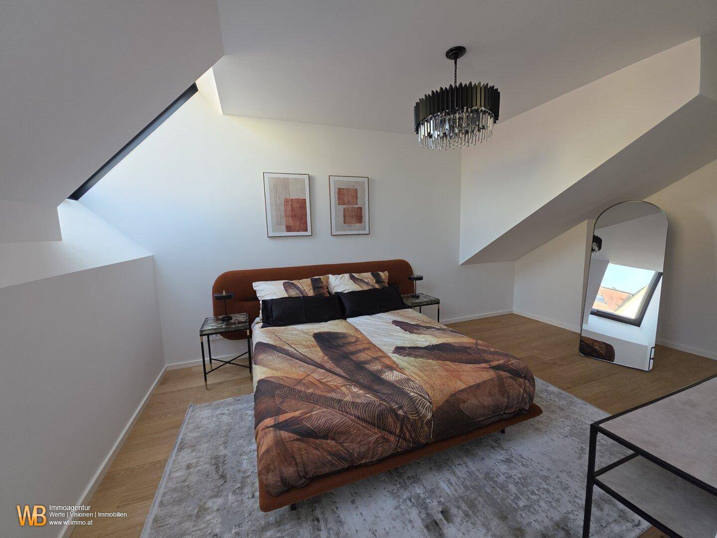 Helles Schlafzimmer mit Holzboden, markanten Dachschrägen und viel Tageslicht durch die Dachfenster.