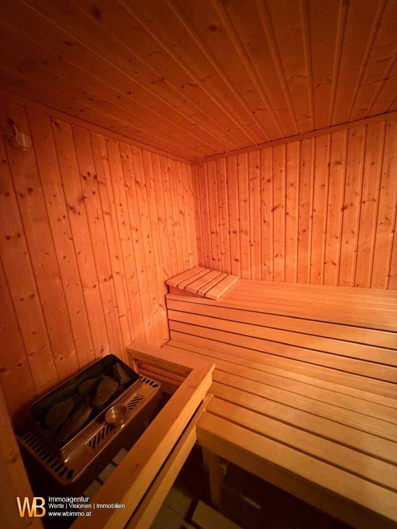 Innenansicht einer Holzsauna mit Bänken und Saunaofen, bereit für entspannende Momente.