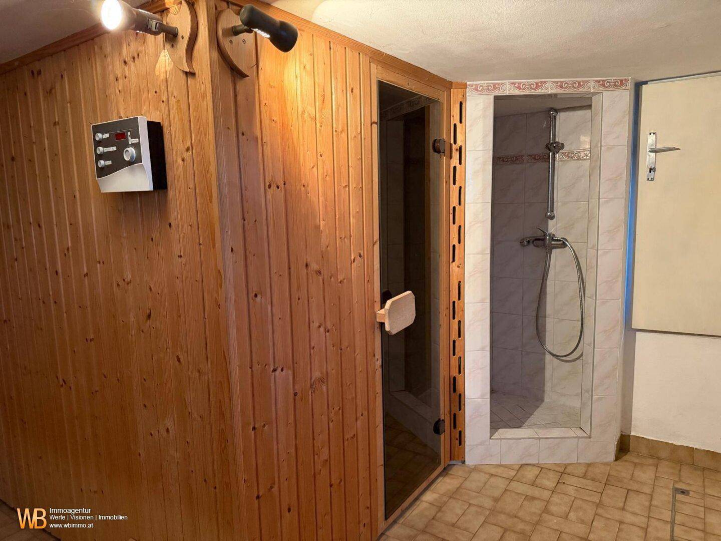 Wellnessbereich mit Holzsauna und angrenzender Duschkabine, ideal zur Entspannung.