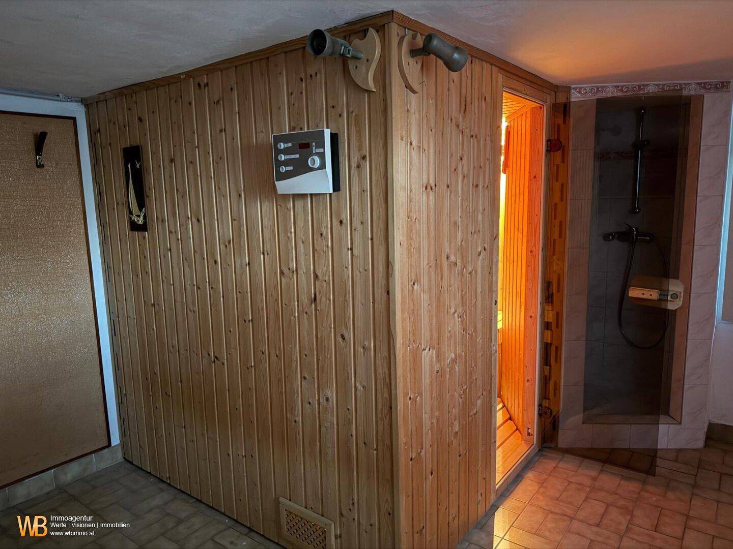 Sauna und Duschbereich mit Holzverkleidung und Fliesenboden, einladend zur Erholung.