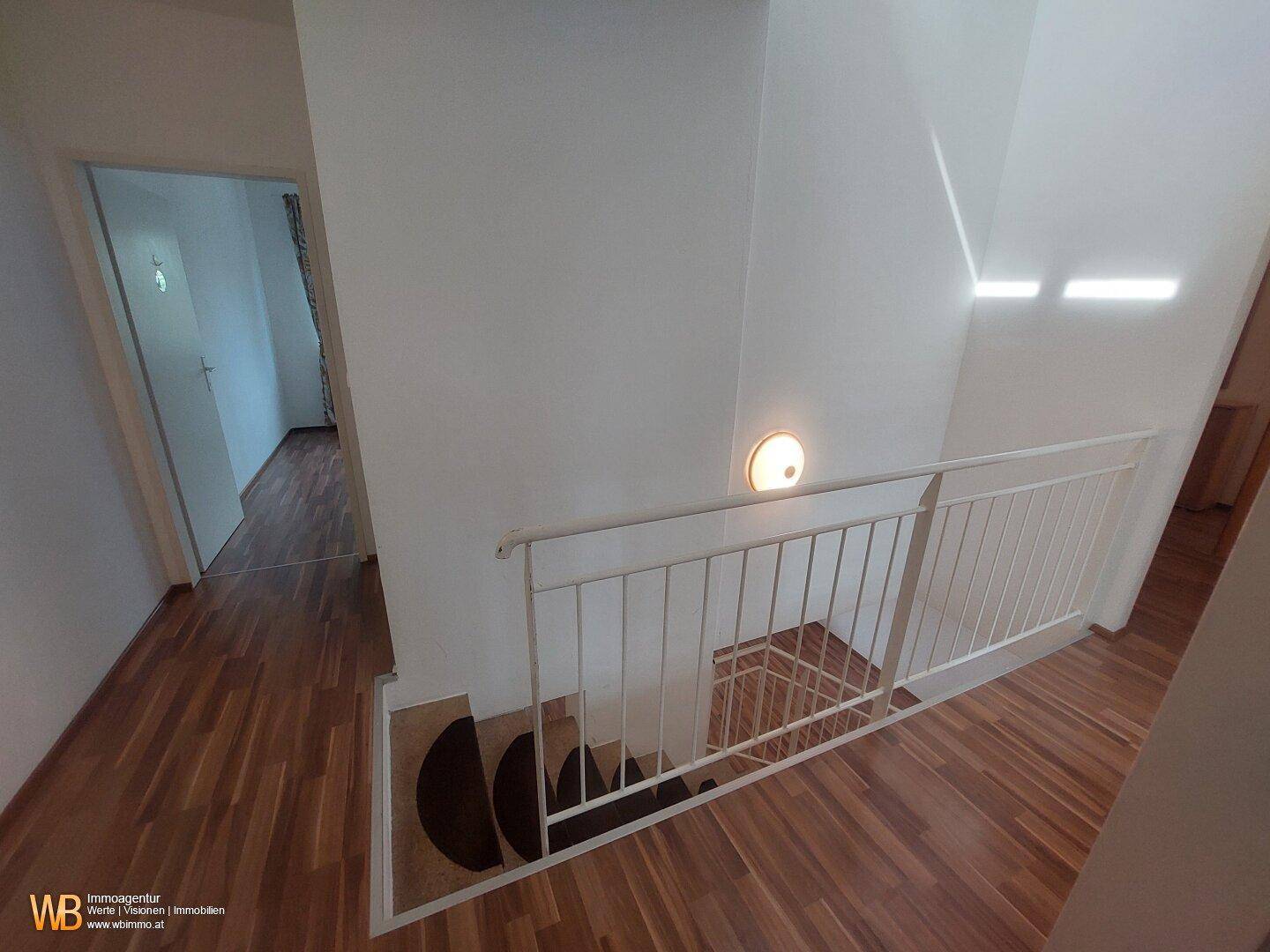 Flur im Obergeschoss mit Blick auf die Treppe und weitere Zimmer.