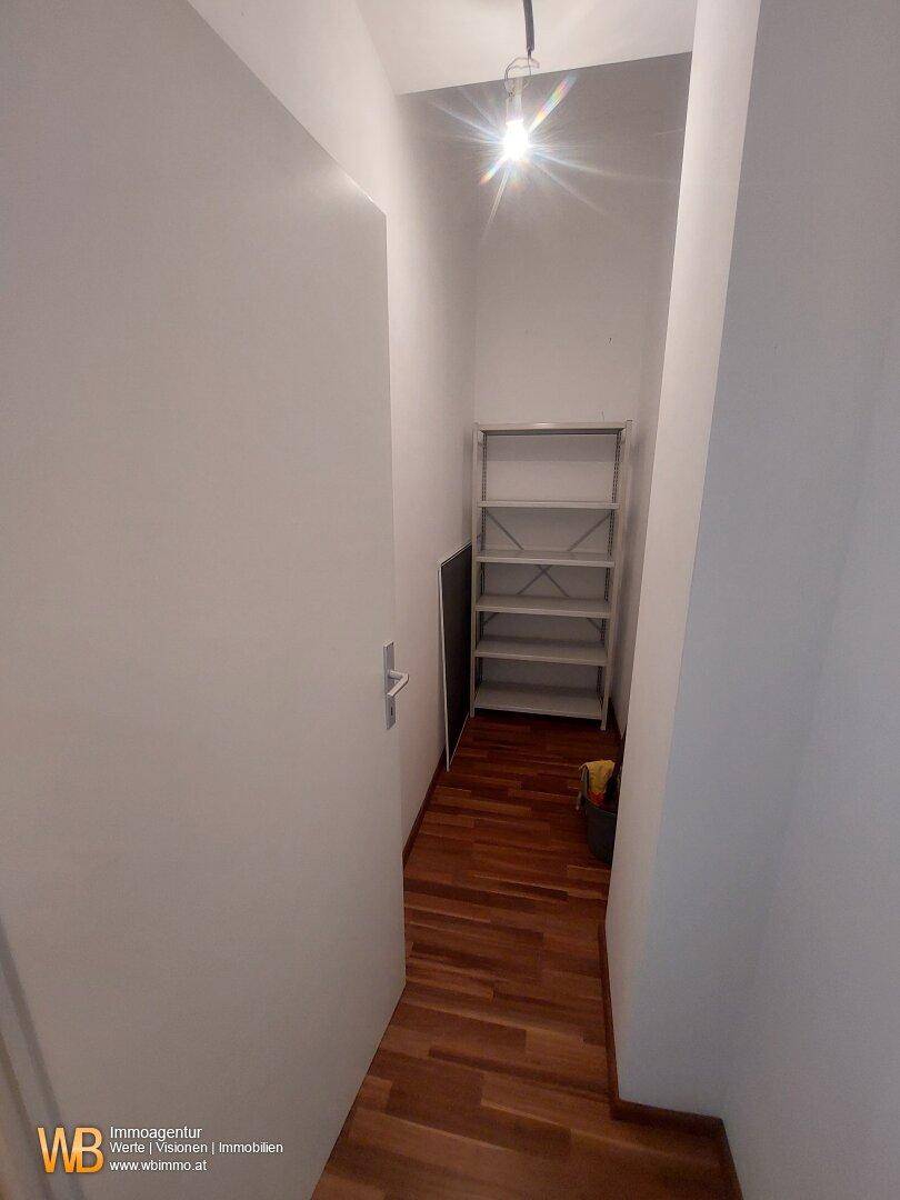 Kleiner Abstellraum mit Regalen und Holzfußboden.