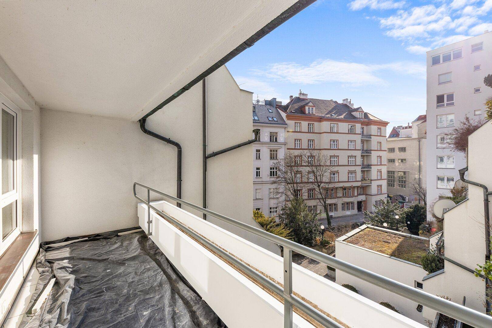 Balkon mit Blick auf die umliegenden Gebäude und den Himmel.