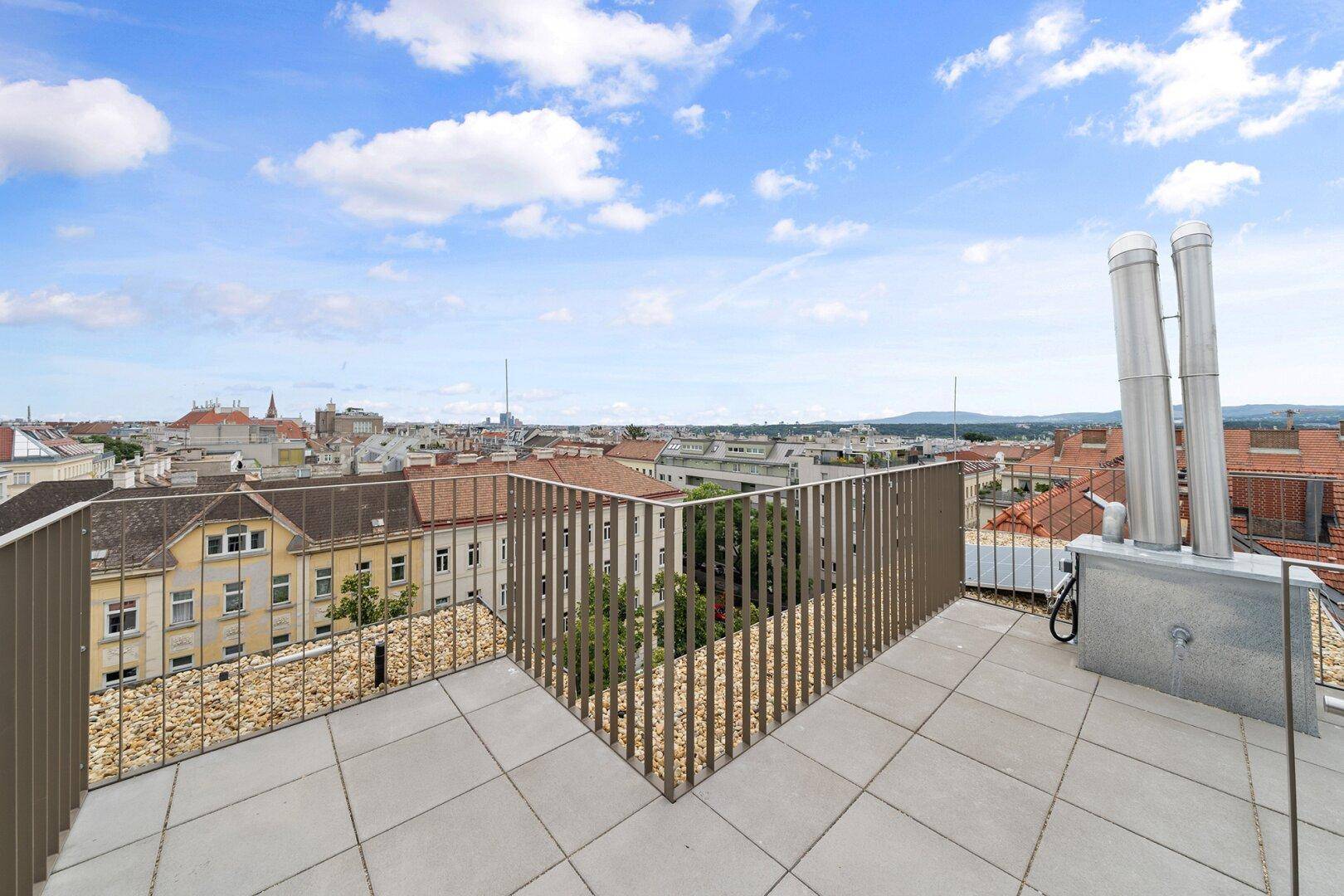 Große Dachterrasse mit Panoramablick über die Stadt und umliegende Gebäude.