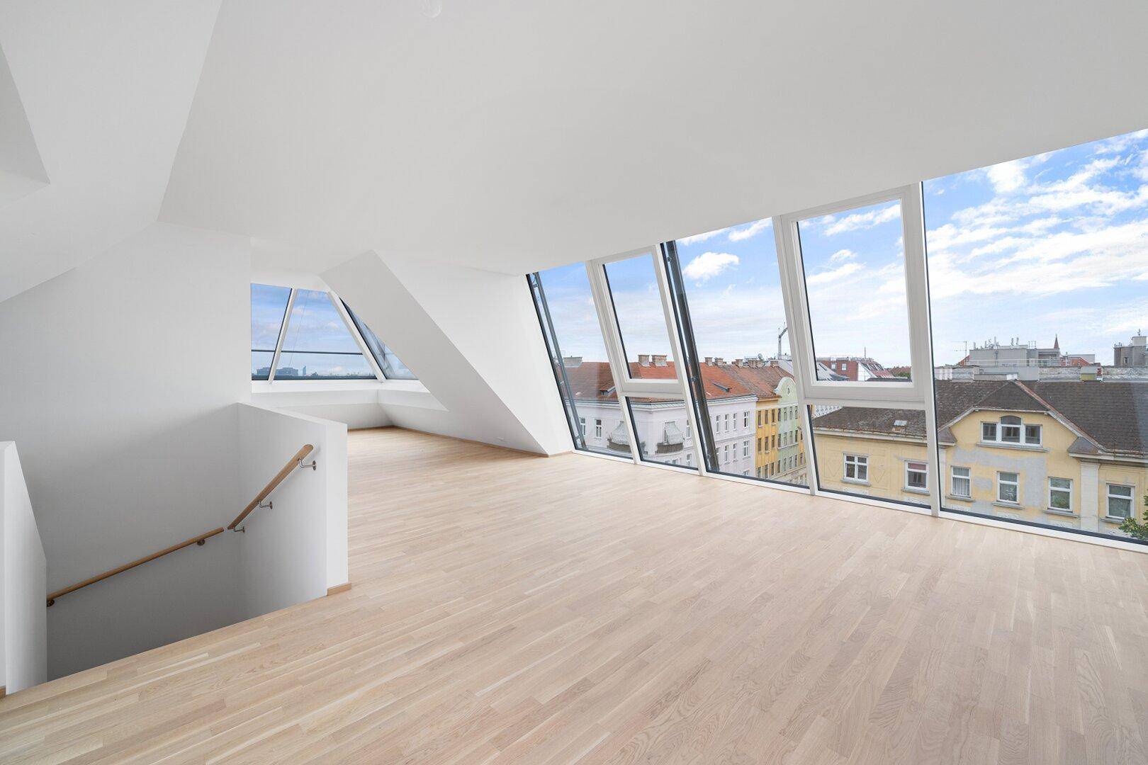 Offener Wohnbereich mit großen Fenstern, Stadtblick und Treppenzugang zu einer weiteren Ebene.