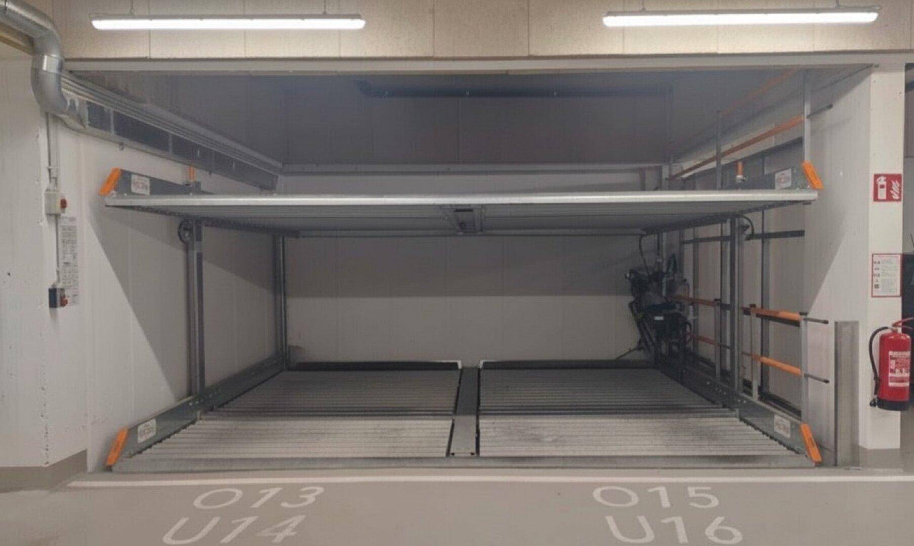 Die Tiefgarage zeigt das Doppelparker-System in abgesenkter Position, bereit zur Aufnahme von zwei Fahrzeugen.