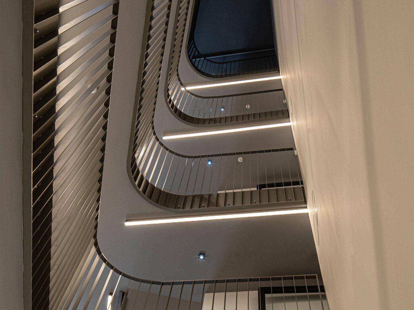 Modernes Treppenhaus mit eleganten Geländern und indirekter Beleuchtung.