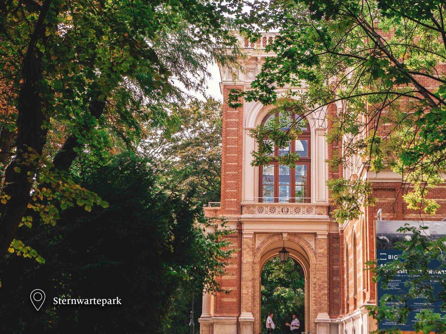Historisches Gebäude mit imposantem Eingangsbereich, umgeben von Bäumen im Sternwartepark.