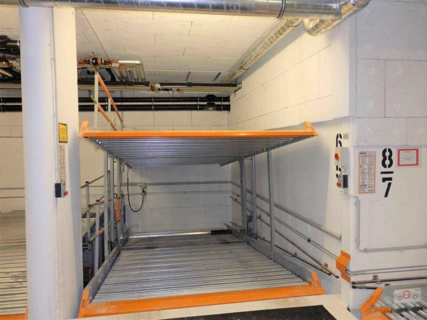 Moderne Tiefgarage mit einem mechanischen Doppelparker-System zur optimalen Raumnutzung und effizientem Parken.