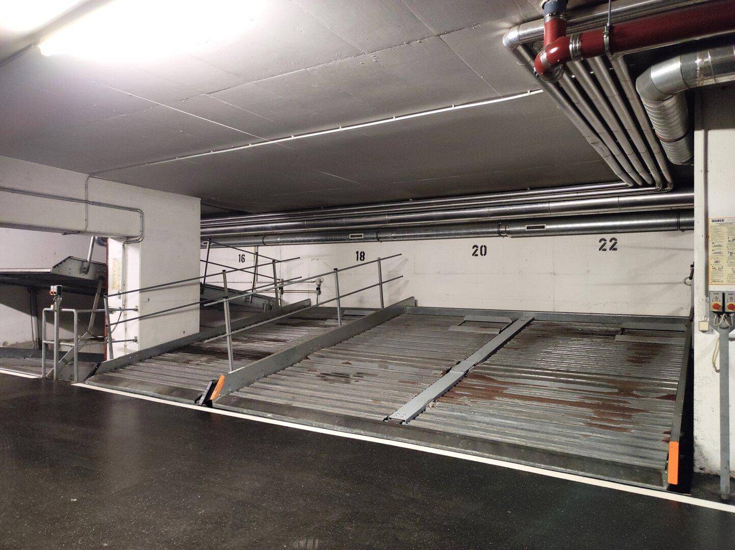 Detailansicht der Doppelparker-Systeme in einer Tiefgarage mit Nummerierungen an der Wand.