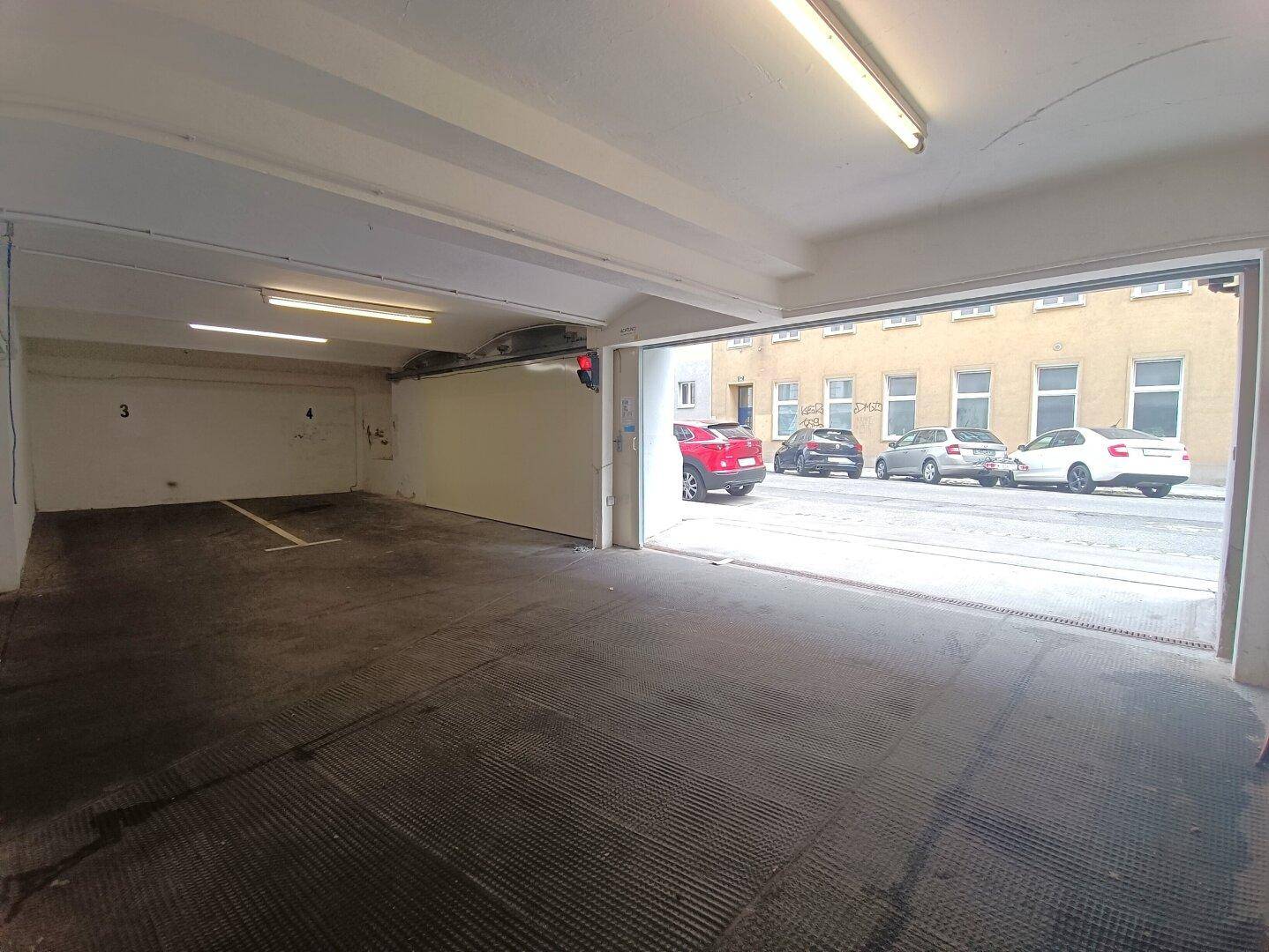 Geräumige Tiefgarage mit mehreren Stellplätzen und direktem Zugang zur Straße.