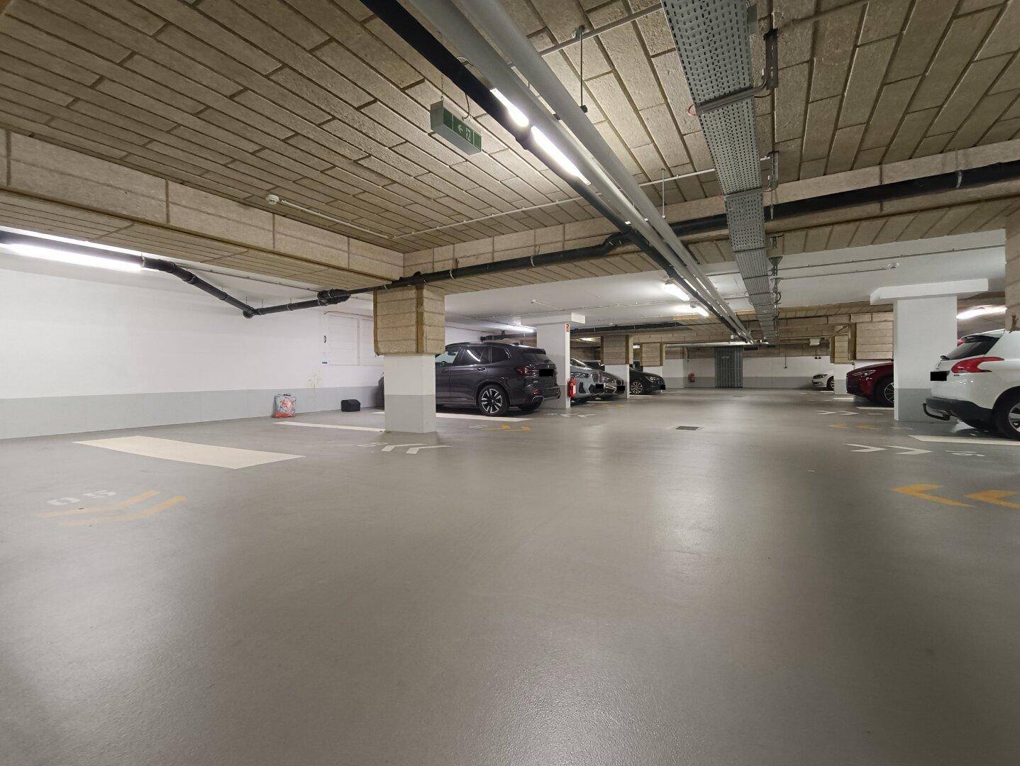 Geräumige Tiefgarage mit mehreren Parkplätzen und guter Beleuchtung.