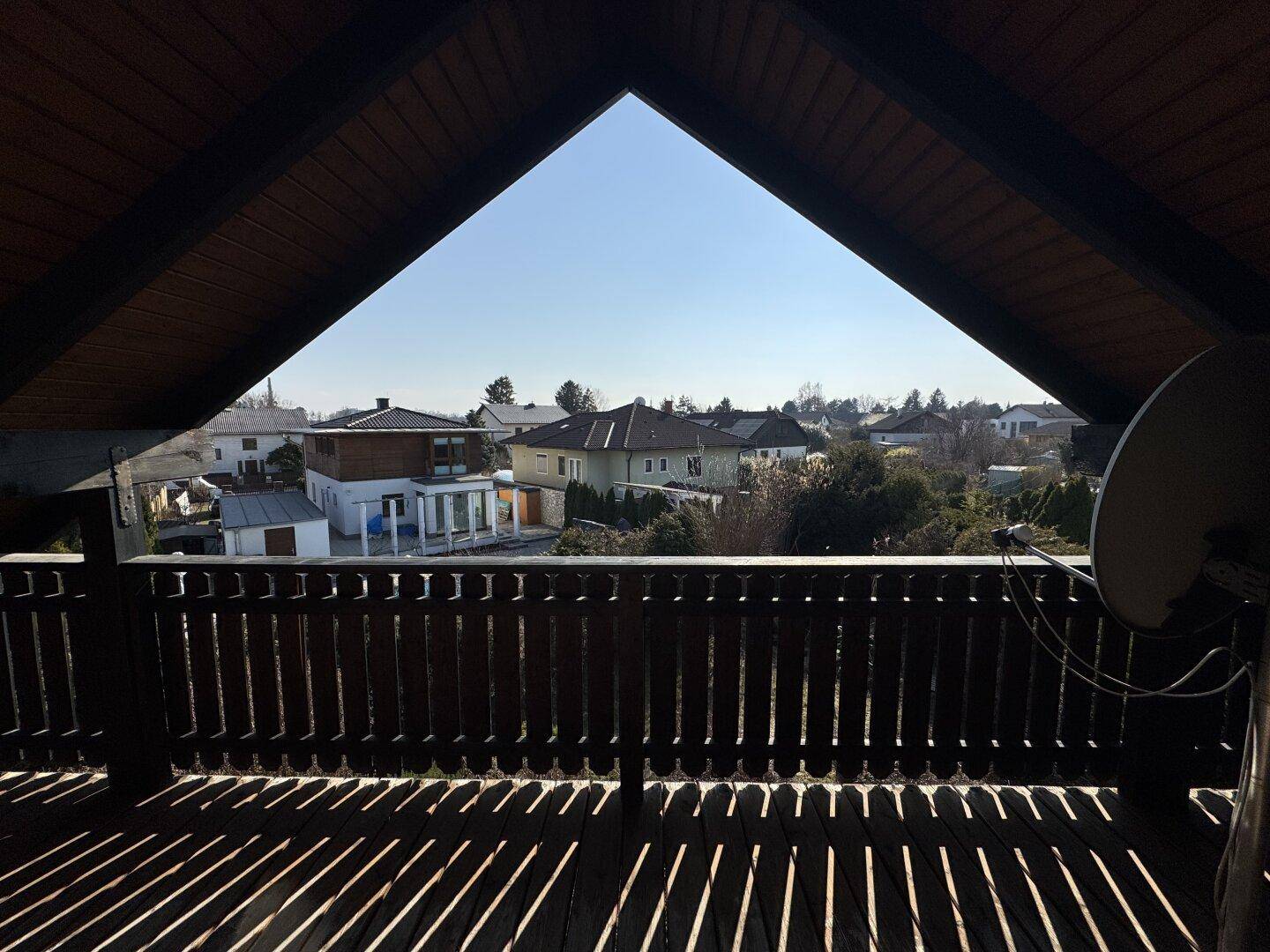 Panoramablick vom Balkon über die umliegende Wohnsiedlung unter einem strahlend blauen Himmel.