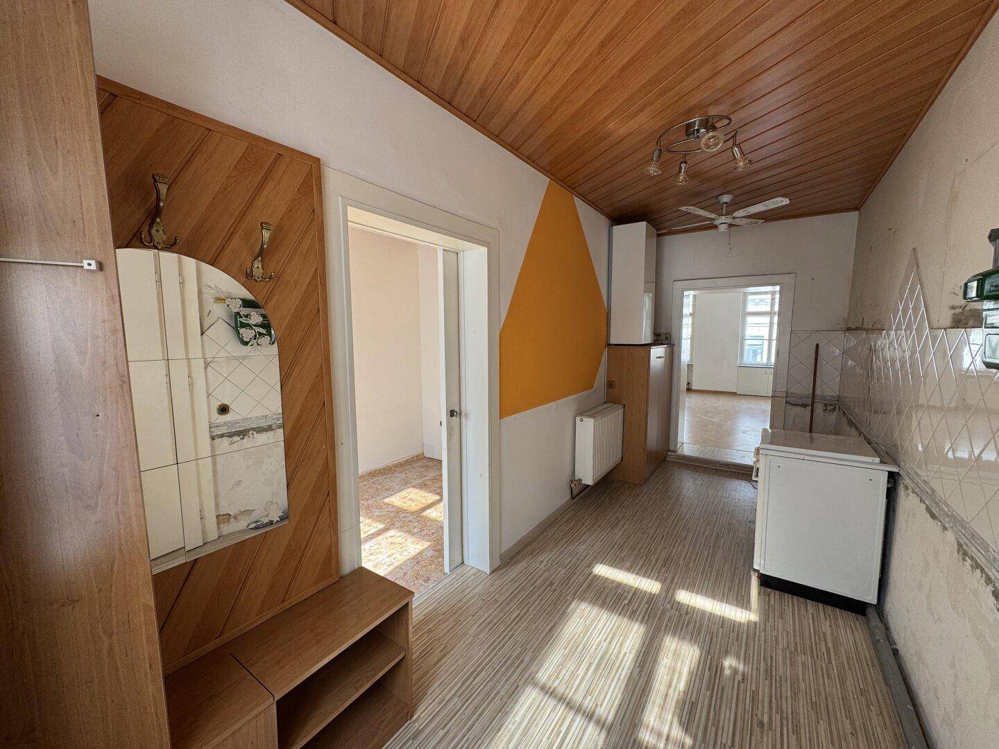 Flur mit Holzdecke, Garderobe und Zugang zu weiteren Räumen.