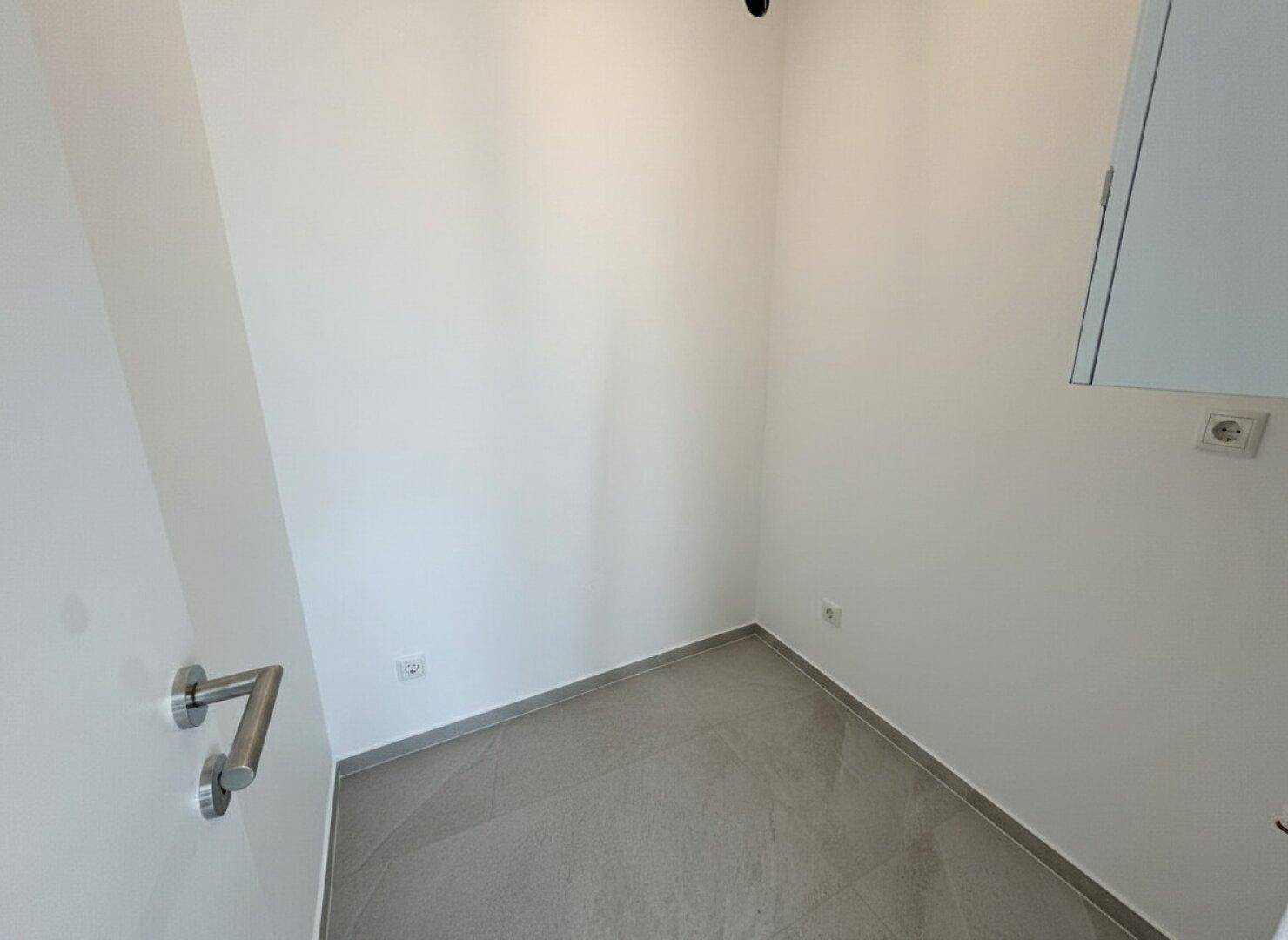 Kleiner, leerer Raum mit Fliesenboden, ideal als Abstellraum oder Speisekammer nutzbar.