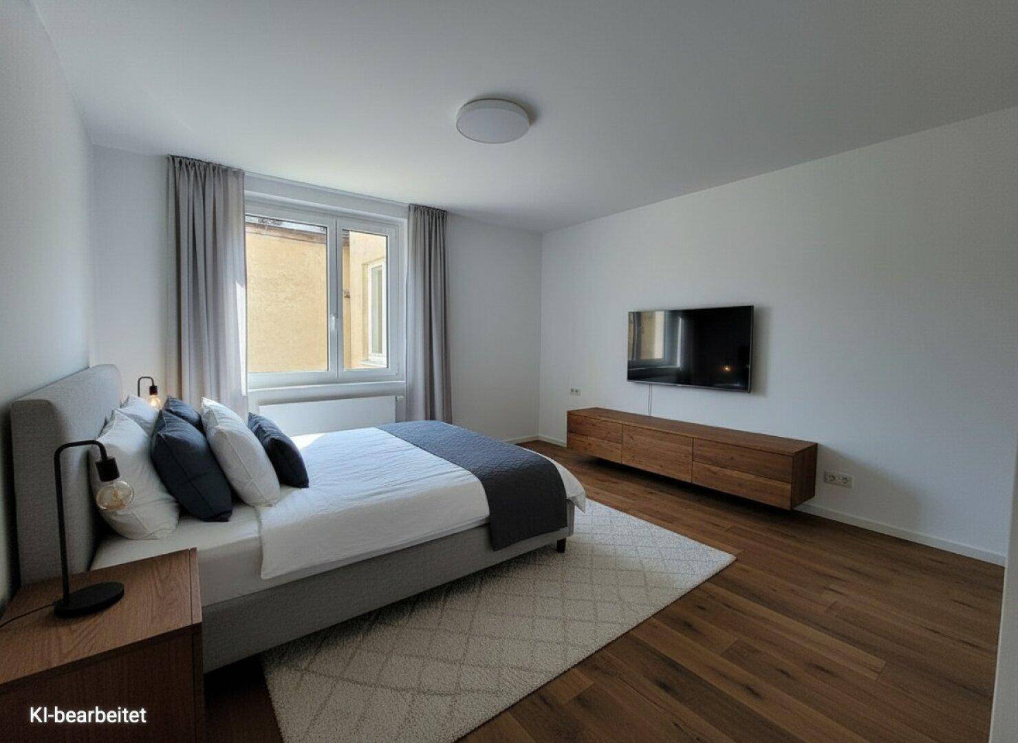 Modern eingerichtetes Schlafzimmer mit Holzboden, großem Bett und einem Fenster.