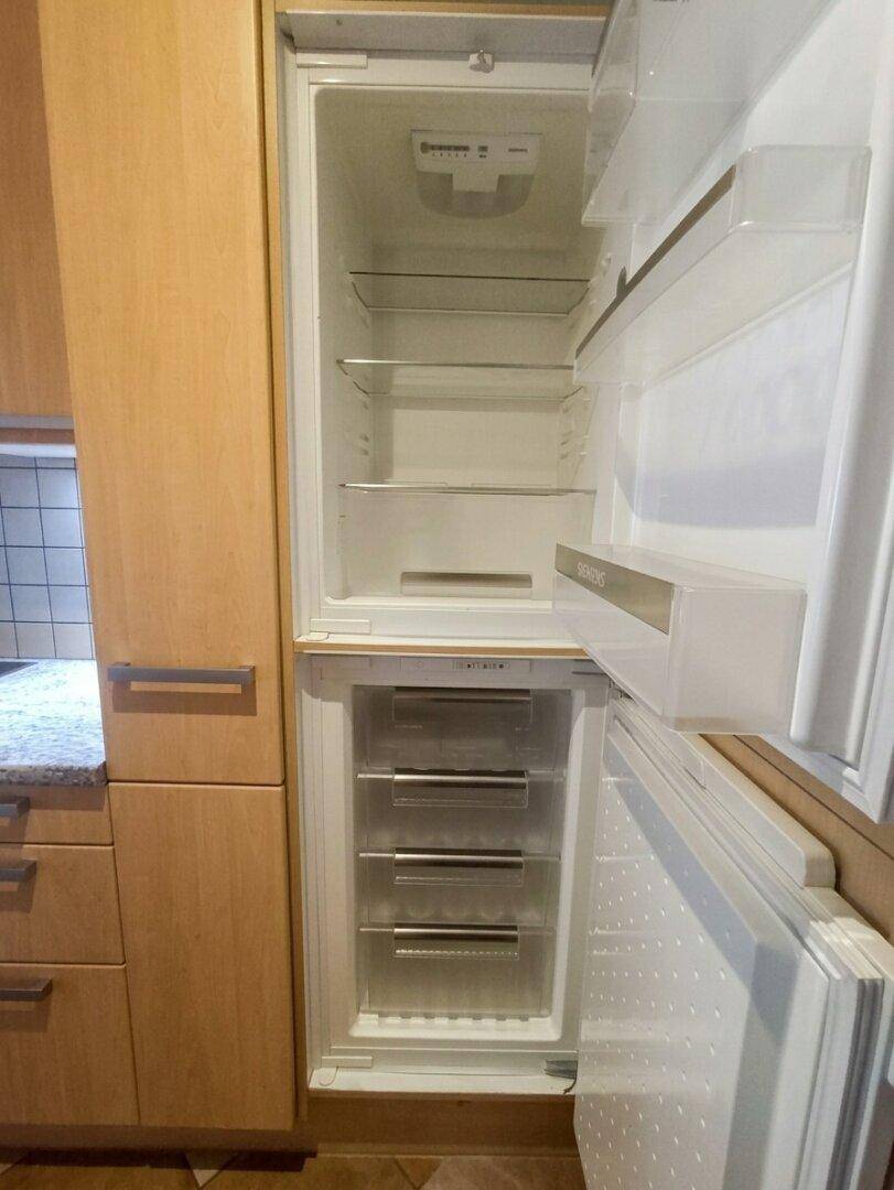Eingebauter Kühlschrank mit Gefrierfach von Siemens, offen und bereit zur Befüllung.