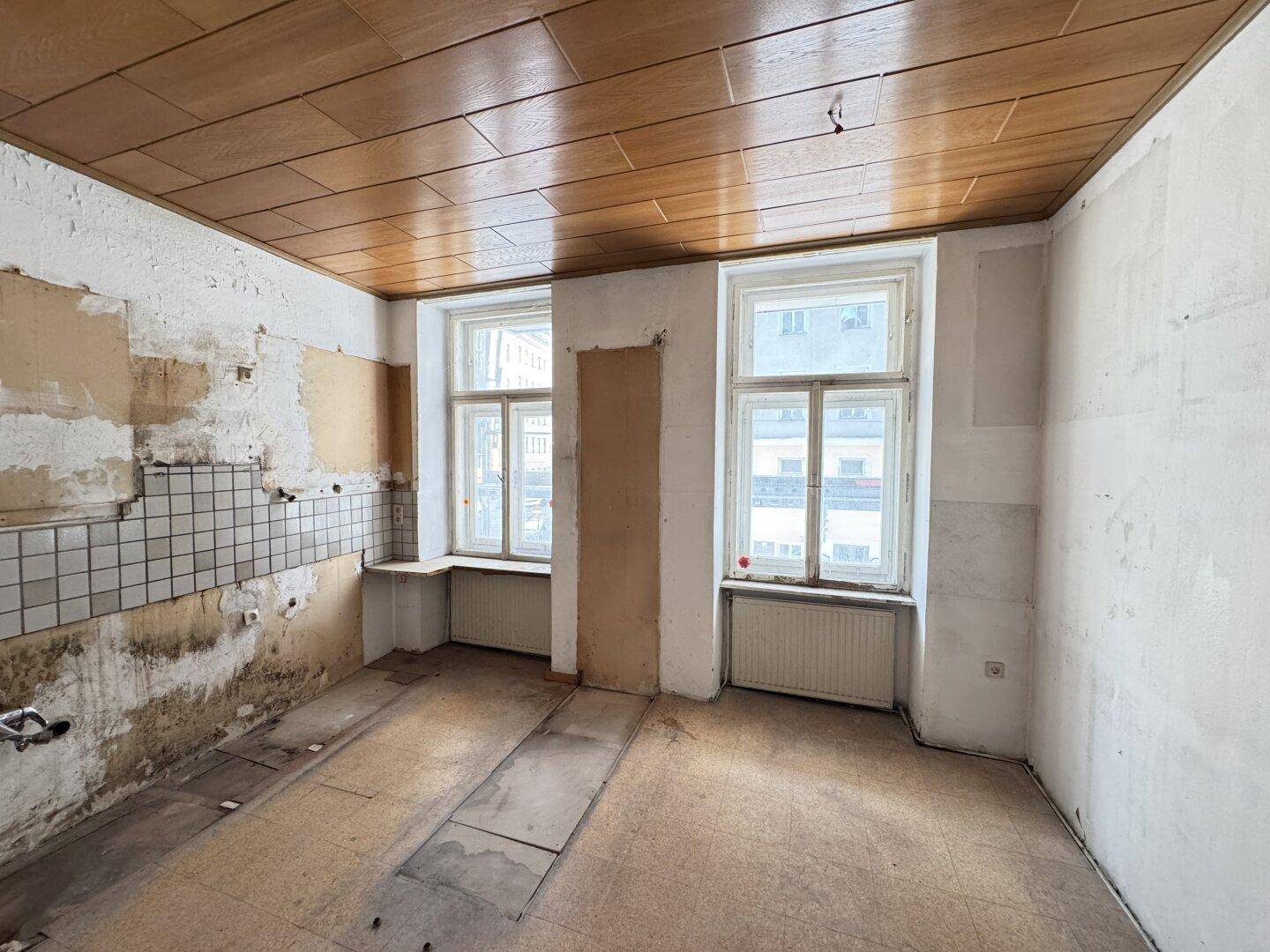 Unfertige Küche mit sichtbaren Wänden und Holzdecke, bereit für eine individuelle Gestaltung.