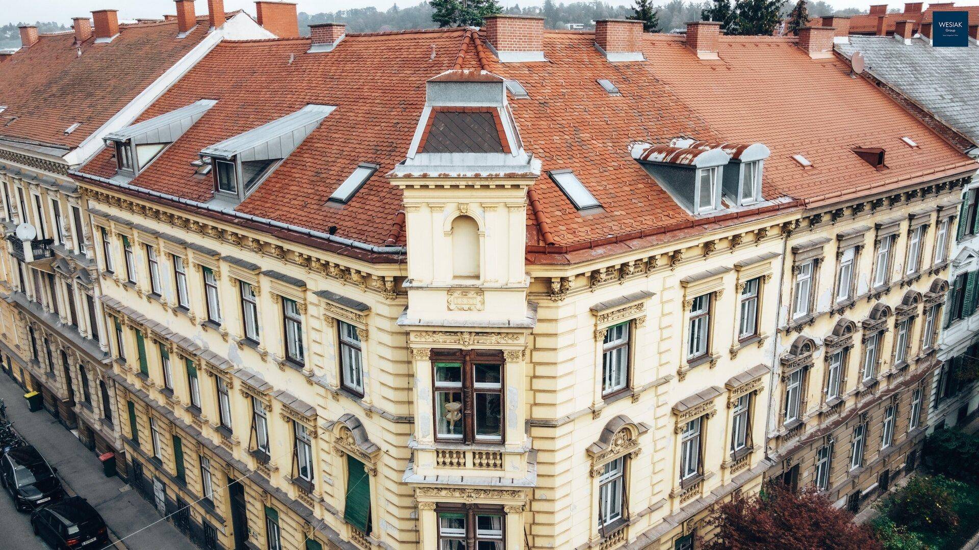 Detailansicht des historischen Eckgebäudes mit kunstvollen Fassadendetails und Dachgauben.