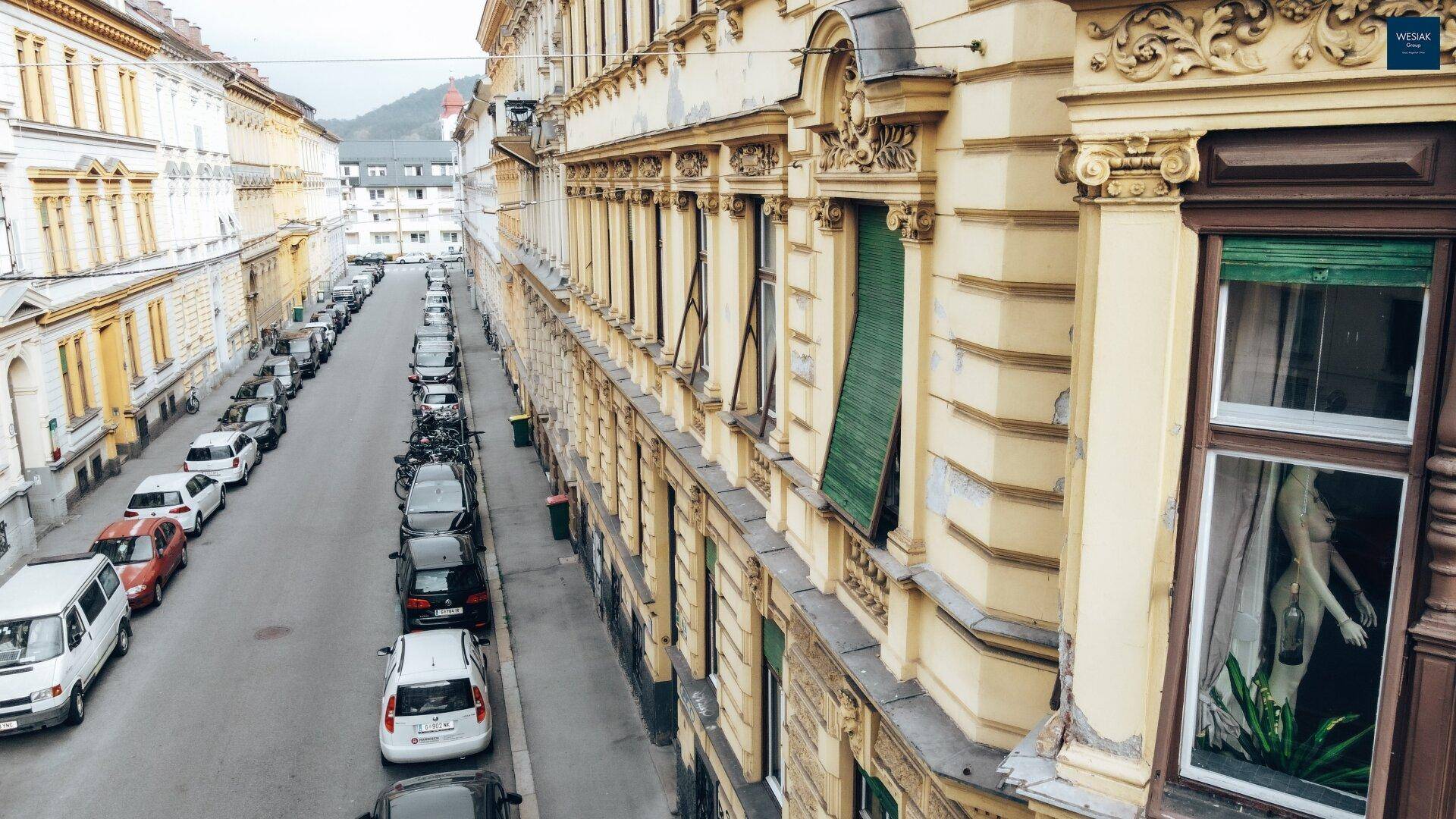 Historische Fassade eines Wohngebäudes mit vielen Fenstern und traditionellen Fensterläden.
