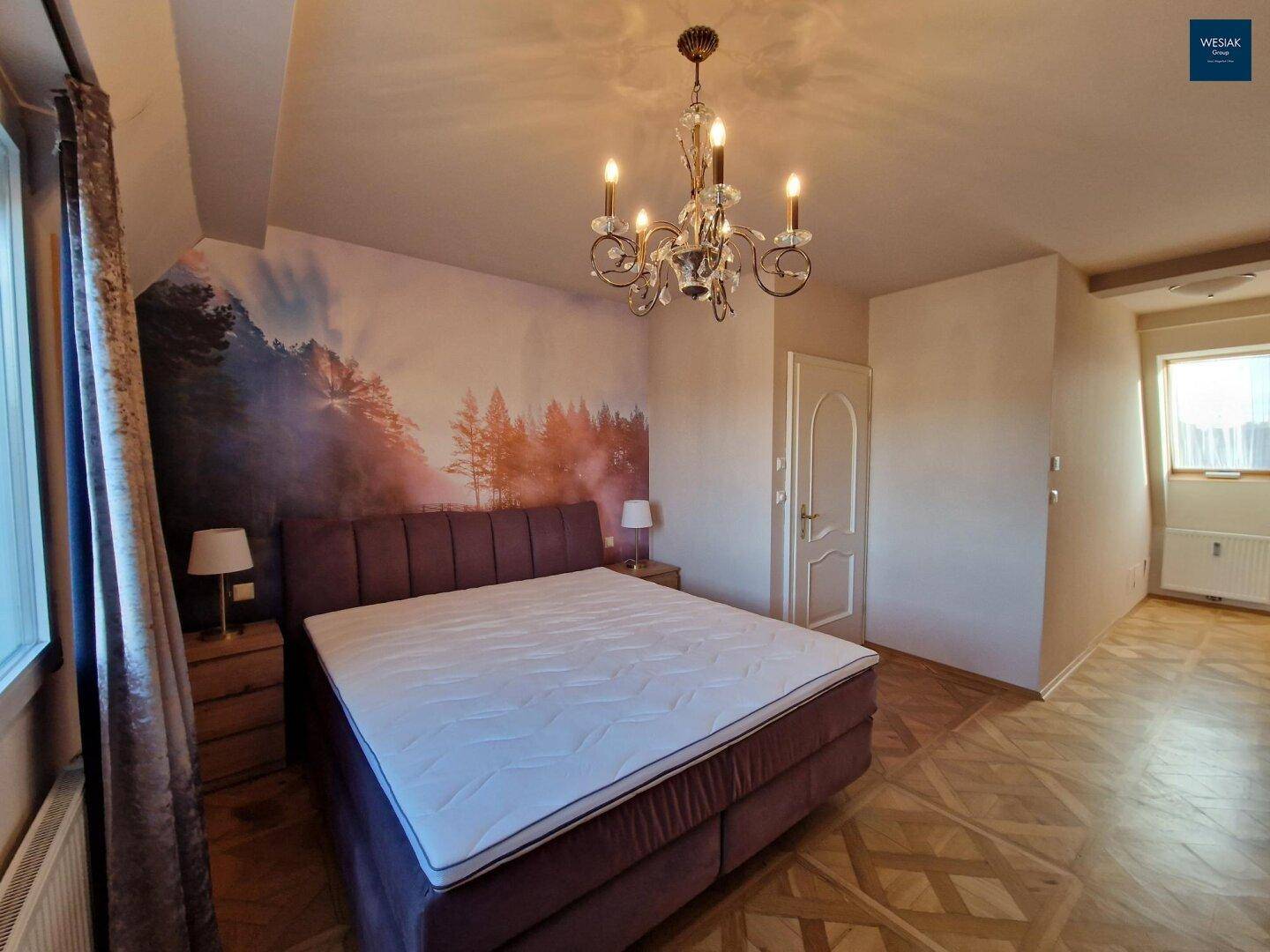 Gemütliches Schlafzimmer mit Doppelbett, dekorativer Wandtapete und Parkettboden.