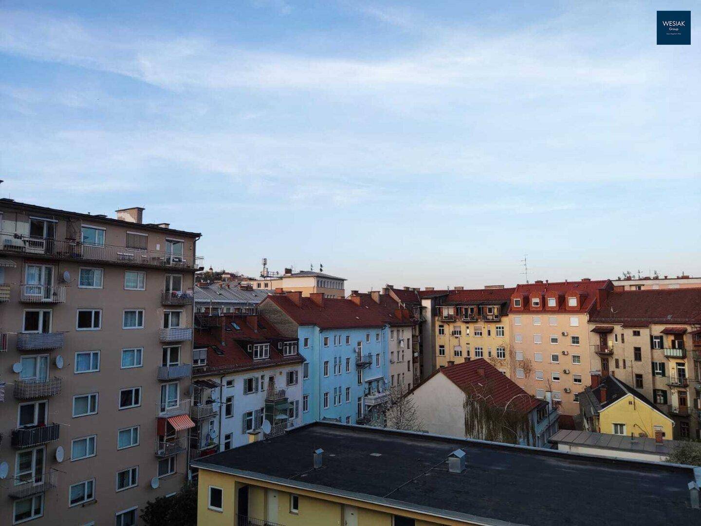 Weitläufiger Blick über die Dächer einer städtischen Wohngegend mit verschiedenen Gebäuden.