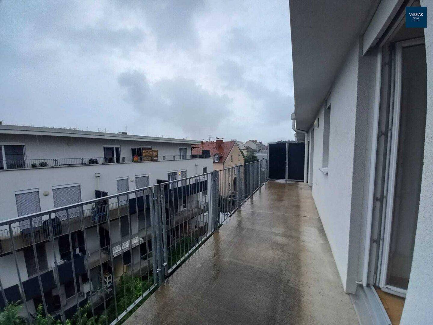 Langer Balkon mit Metallgeländer und Blick auf die Umgebung, ideal zum Entspannen.