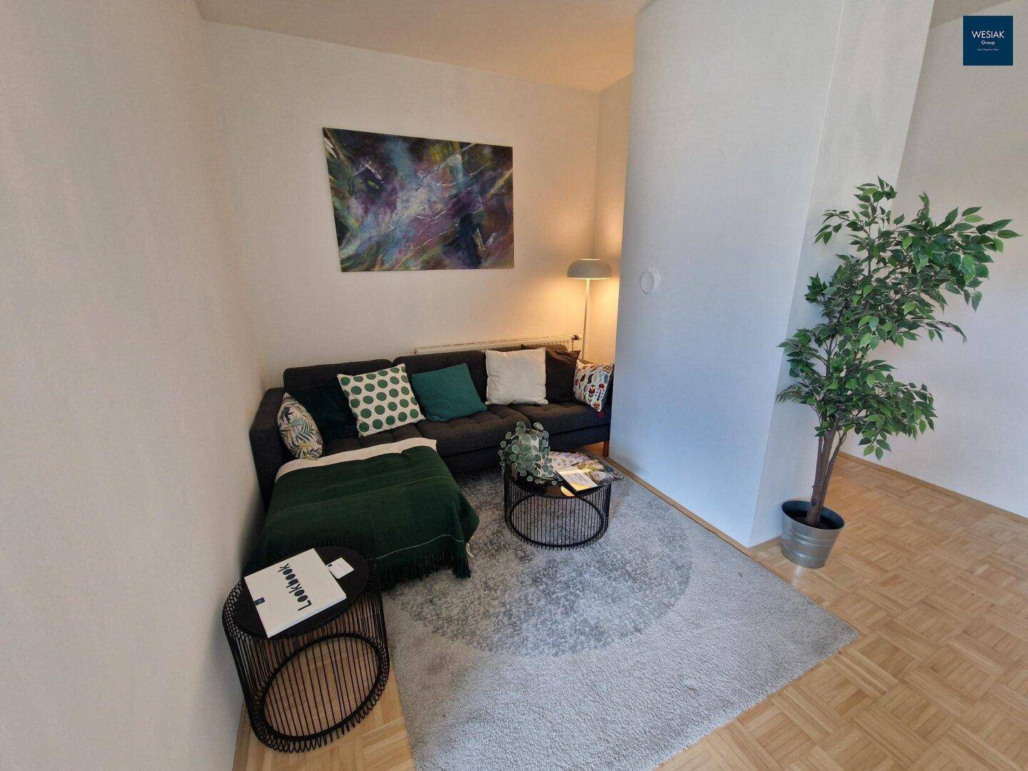 Gemütliches Wohnzimmer mit Sofa, Teppich und modernem Kunstwerk an der Wand.