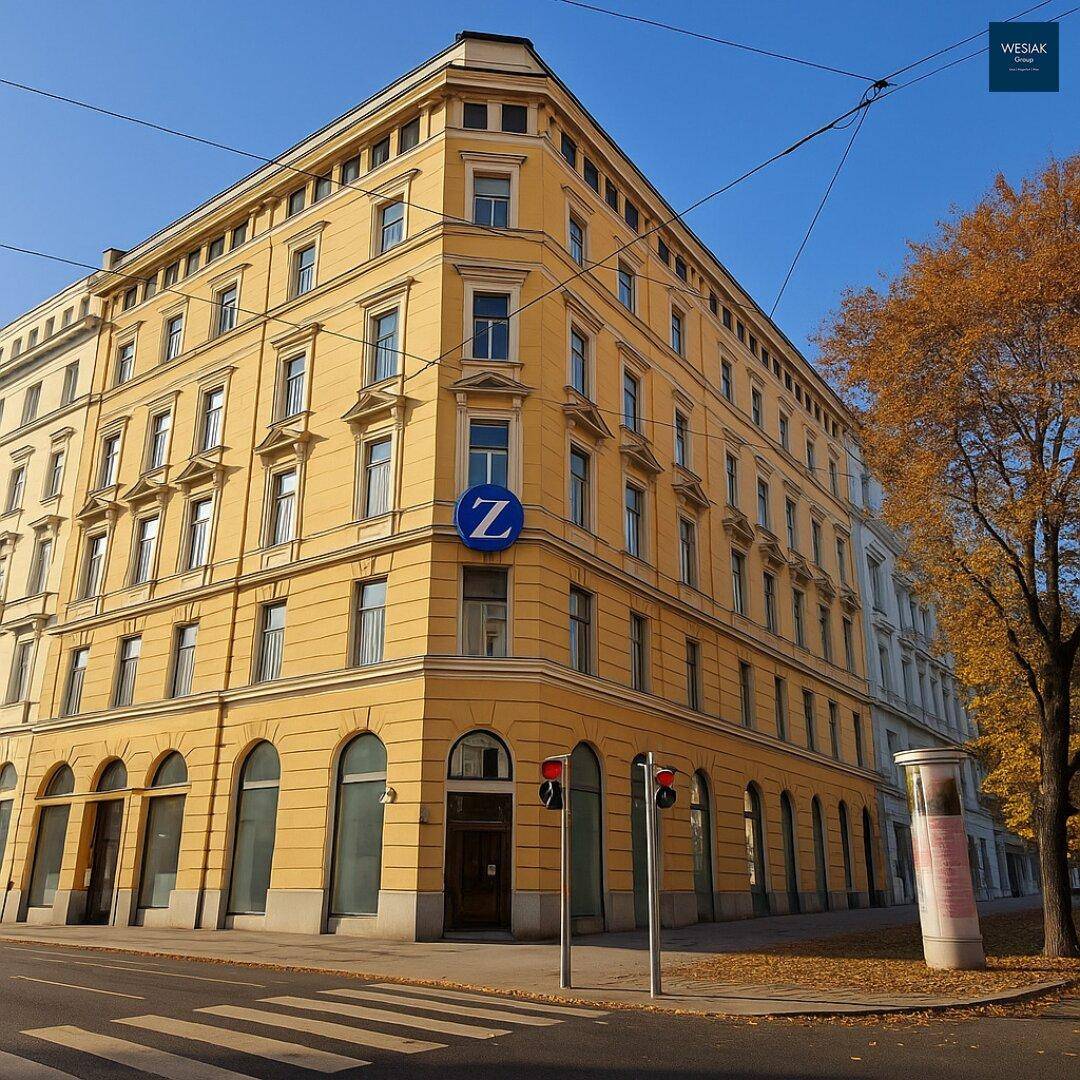 Historisches Eckgebäude mit gelber Fassade, vielen Fenstern und architektonischen Details an einer Stadtstraße.