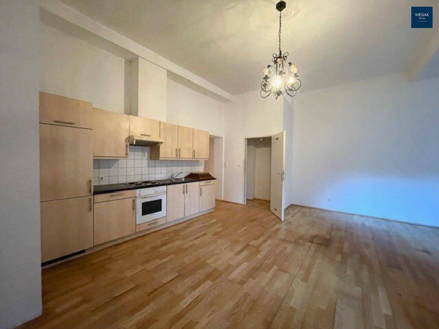 Funktionale Einbauküche mit hellen Holzfronten und Gasherd in einem offenen Wohnbereich.