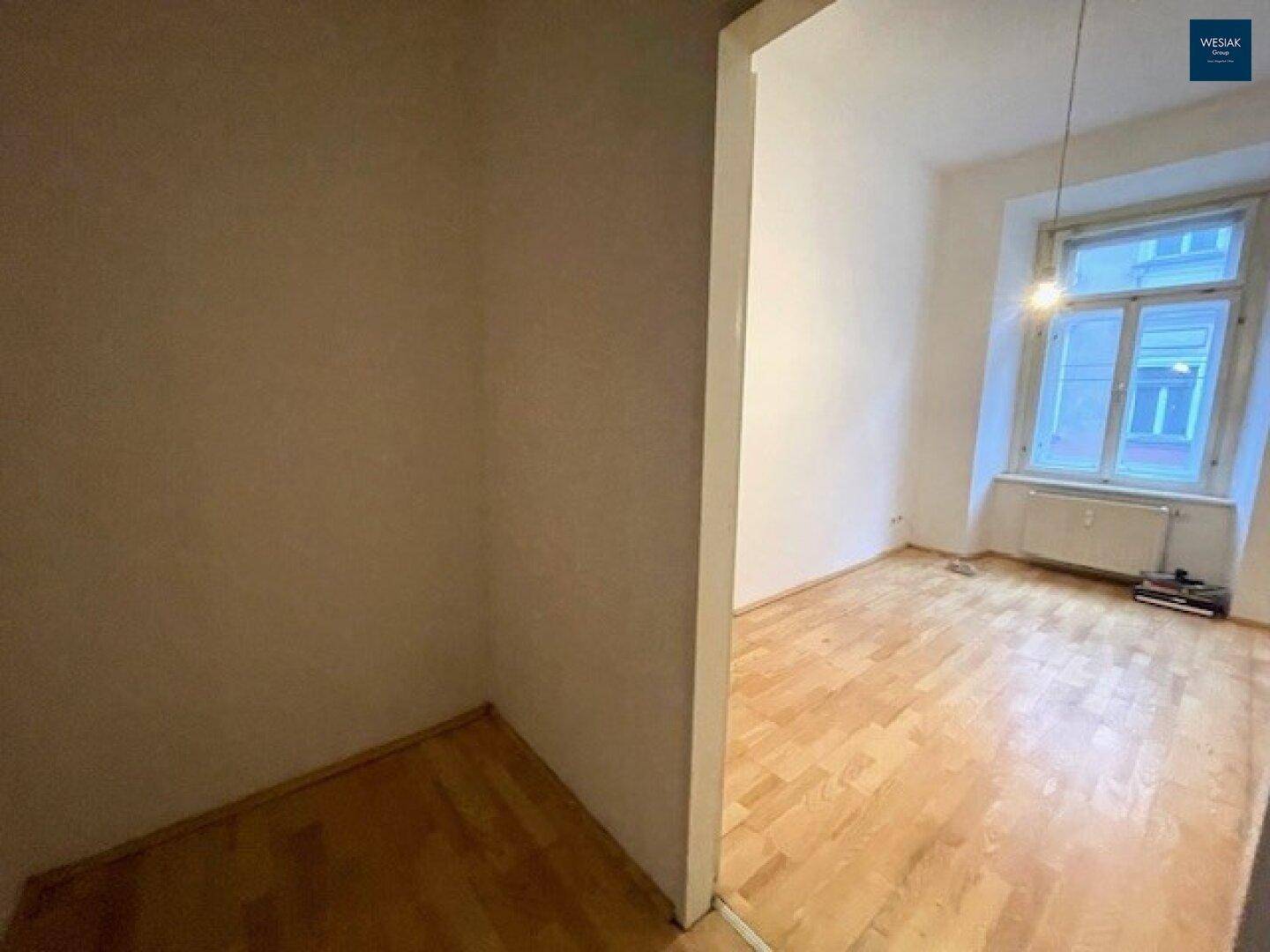 Schlafzimmer mit Parkettboden und Blick aus dem Fenster, ideal für Ruhe und Erholung.